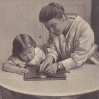 The teacher sitting beside the child, Elsa Ochs, is very slowly and carefully demonstrating the finger movements needed and encouraging the child to watch closely. Postcard published by the DMG (German Montessori Society) around 1927 with the inscription: "As soon as the child has learnt buttoning and lacing, he will also want to use his skills. He is proud of no longer needing help to dress himself." - T. Müller, R. Schneider, <em>Lehrmaterialien 1913-1935. Möbel und Architektur. Techning Meterials 1913-1935. Furniture and Architecture</em>, München, Prestel Verlag, 2002, p.78$$$407