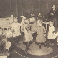 Music and dance in a Children's House on Leopoldplatz, Berlin-Wedding. Postcard published by the DMG (German Montessori Society), around 1927. The boy and girl in the bottom left-hand corner of the picture are accompanying their teacher, who is playing the violin, on the triangle and tambourine - T. Müller, R. Schneider, L<em>ehrmaterialien 1913-1935. Möbel und Architektur. Techning Meterials 1913-1935. Furniture and Architecture</em>, München, Prestel Verlag, 2002, p.24.$$$369