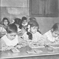 Bambini che toccano le lettere smerigliate [Casa dei Bambini a San Lorenzo, Roma, 1907-1909] - M. Montessori, <i>Il metodo della pedagogia scientifica applicato all’educazione infantile nelle Case dei Bambini</i>, Città di Castello, Tipografia della Casa Editrice S. Lapi, 1909.$$$72