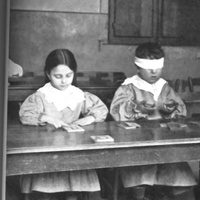 Bambini che si esercitano al tocco delle lettere smerigliate e bambino che fa esercizi del senso barico [Casa dei Bambini a San Lorenzo, Roma, 1907-1909] - M. Montessori, <i>Il metodo della pedagogia scientifica applicato all’educazione infantile nelle Case dei Bambini</i>, Città di Castello, Tipografia della Casa Editrice S. Lapi, 1909.$$$75